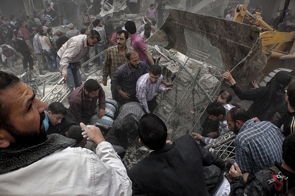 Alcuni uomini dopo un attacco aereo sulla città di Aleppo il 7 aprile 2013 (VICTOR BREINER/AFP/Getty Images)