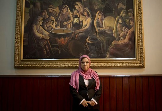 La deputata Shukria Kaihan in posa sotto a un dipinto nel parlamento afghano a Kabul, 26 marzo 2014 (AP Photo/Anja Niedringhaus)